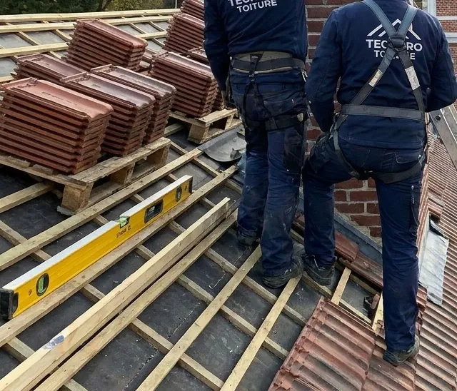 Pannes empilées sur les liteaux et niveau de couvreur